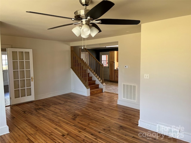 spare room with hardwood / wood-style flooring, stairs, and visible vents