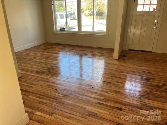 foyer with baseboards and wood finished floors