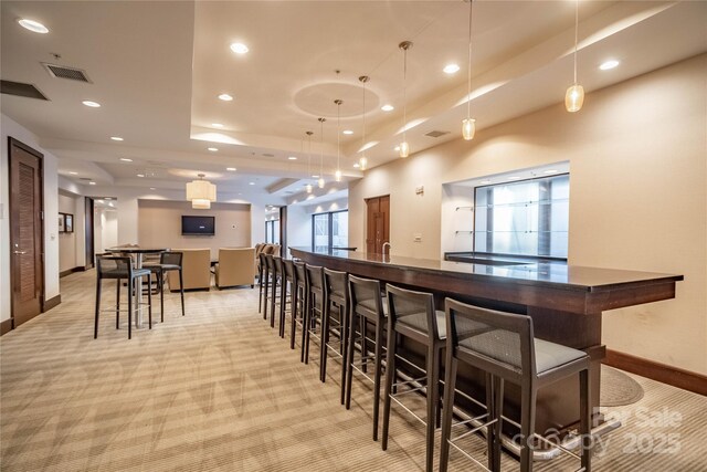 230 S Tryon St Unit 610, Charlotte, NC 28202 - bar featuring recessed lighting, a tray ceiling, light carpet, decorative light fixtures, and baseboards
