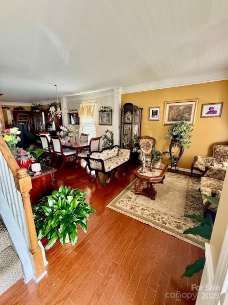 living area featuring ornamental molding and wood finished floors