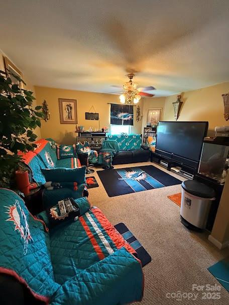 carpeted living area with ceiling fan