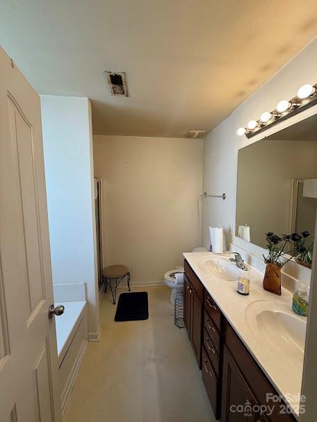 bathroom featuring a garden tub, a sink, double vanity, toilet, and visible vents