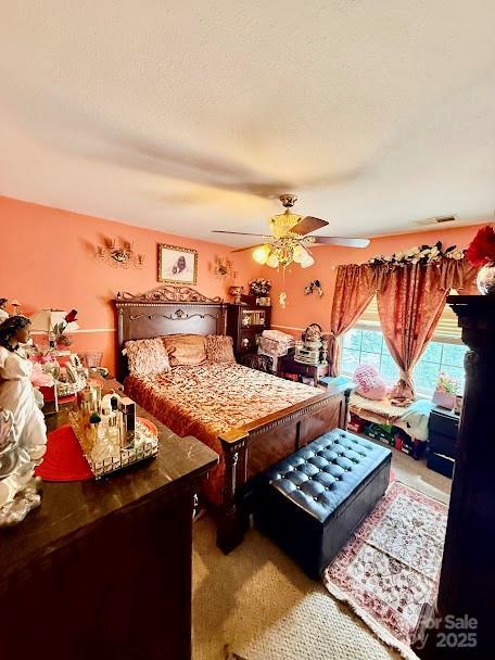 bedroom featuring a ceiling fan, visible vents, and carpet