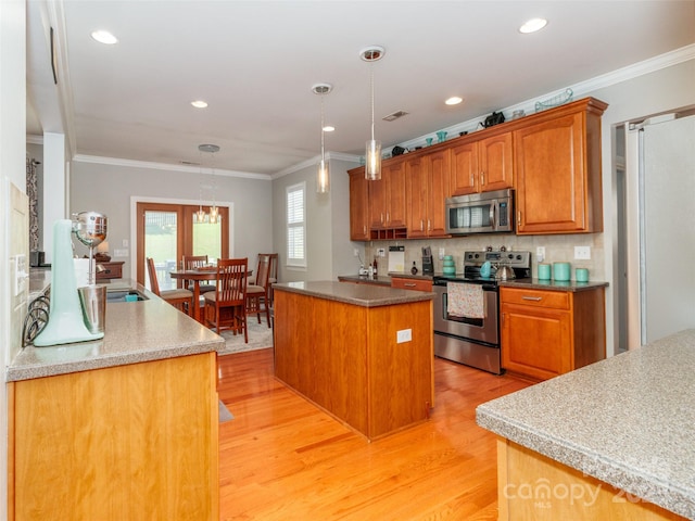 706 Springwood Dr Unit 14, Waxhaw, NC 28173 - kitchen featuring crown molding, light wood-type flooring, and stainless steel appliances