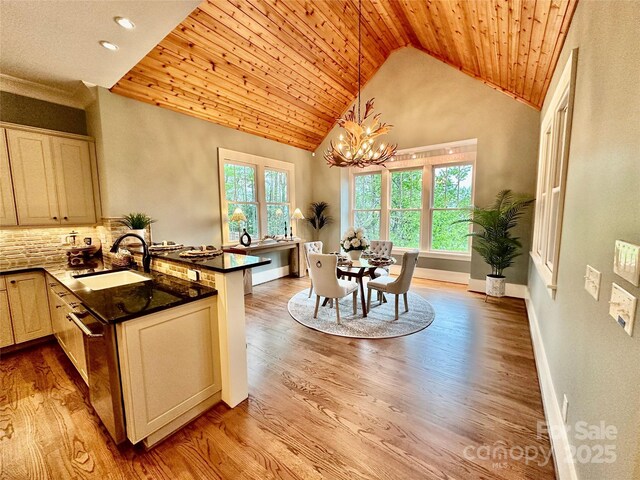 18420 Rosapenny Rd, Charlotte, NC 28278 - kitchen featuring a sink, a peninsula, a chandelier, dark countertops, and light wood-type flooring