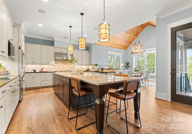 18420 Rosapenny Rd, Charlotte, NC 28278 - kitchen with a breakfast bar area, stainless steel appliances, light wood finished floors, decorative backsplash, and light stone countertops