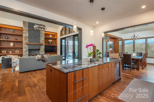 158 Riverbend Forest Dr Unit 15, Asheville, NC 28805 - kitchen featuring dark wood-type flooring, dark stone counters, modern cabinets, a kitchen island, and a chandelier
