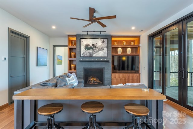 158 Riverbend Forest Dr Unit 15, Asheville, NC 28805 - bar with a ceiling fan, light wood finished floors, a large fireplace, and built in shelves