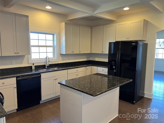 kitchen with dark wood-style floors, black appliances, dark stone countertops, and a sink