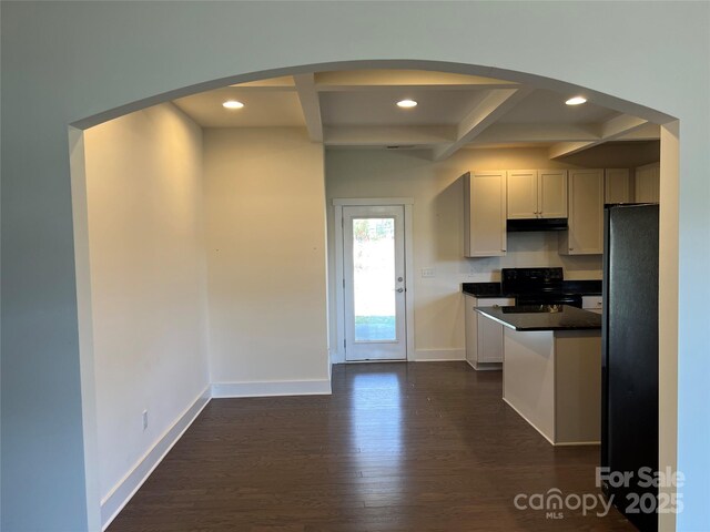 kitchen with coffered ceiling, dark wood finished floors, dark countertops, black electric range, and arched walkways