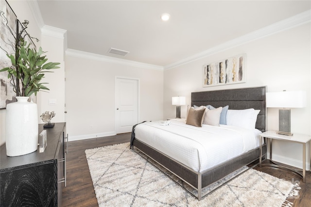 bedroom featuring dark wood-style flooring, baseboards, ornamental molding, and visible vents