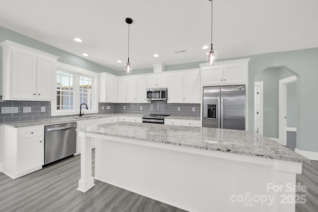 1380 Bowers Rd, Peachland, NC 28133 - kitchen featuring white cabinets, light wood-style flooring, stainless steel appliances, a sink, and a center island