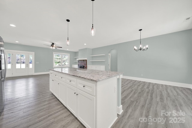 1380 Bowers Rd, Peachland, NC 28133 - kitchen featuring light wood-style flooring, baseboards, ceiling fan with notable chandelier, open floor plan, and a center island