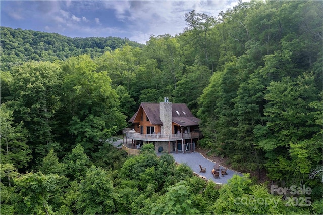 bird's eye view with a wooded view