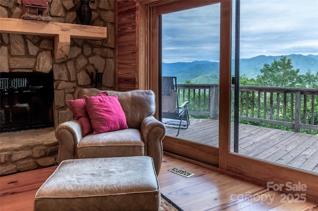 interior space with visible vents, a mountain view, wood finished floors, and a fireplace