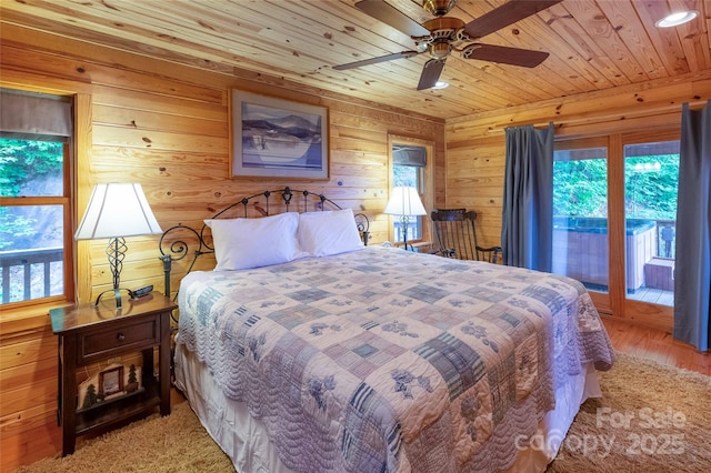 bedroom with access to outside, ceiling fan, light wood-style floors, wood walls, and wood ceiling