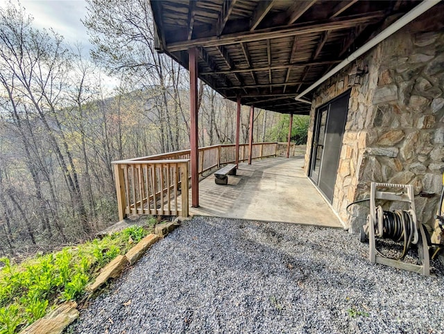 view of patio with a view of trees and a wooden deck