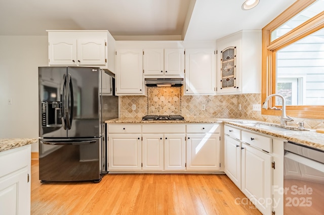 5232 Silchester Ln, Charlotte, NC 28215 - kitchen with black fridge with ice dispenser, under cabinet range hood, dishwasher, gas cooktop, and light wood-style flooring