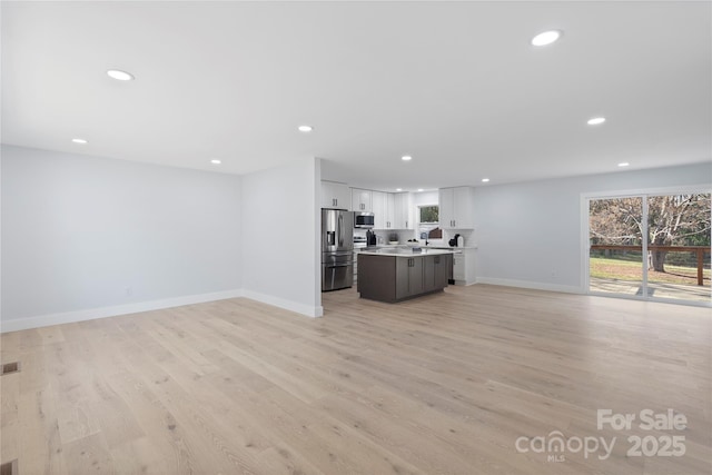 1315 Vickie Ln, Matthews, NC 28104 - unfurnished living room featuring recessed lighting, plenty of natural light, and light wood-style flooring
