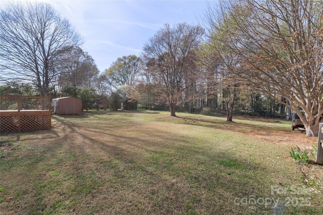 1315 Vickie Ln, Matthews, NC 28104 - view of grassy yard featuring a shed and a wooden deck
