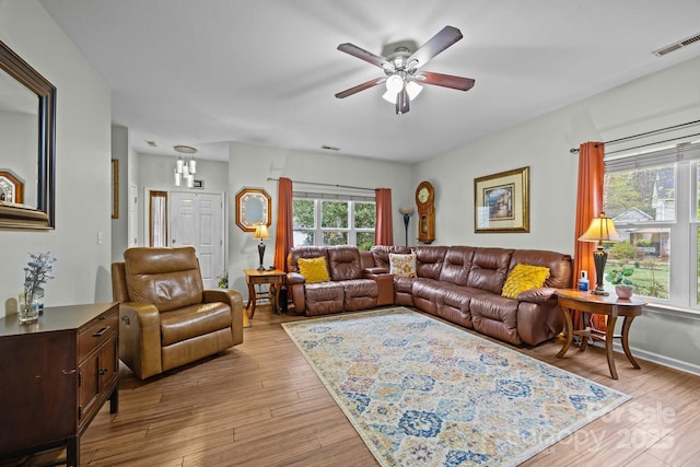 living room with a ceiling fan, baseboards, light wood finished floors, and visible vents