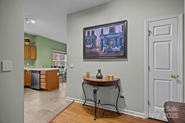hallway featuring light wood-style flooring and baseboards