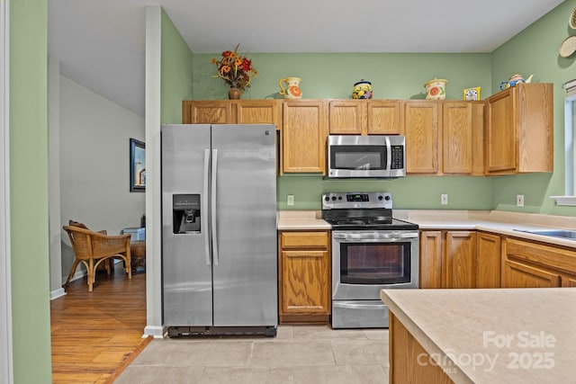 kitchen featuring light countertops, light tile patterned floors, and appliances with stainless steel finishes