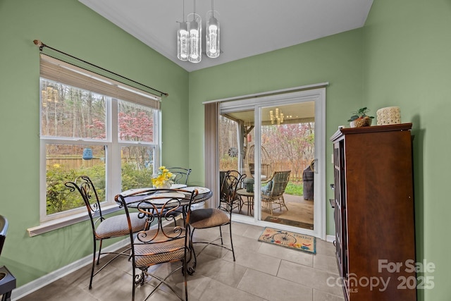 dining area featuring light tile patterned flooring, baseboards, and an inviting chandelier