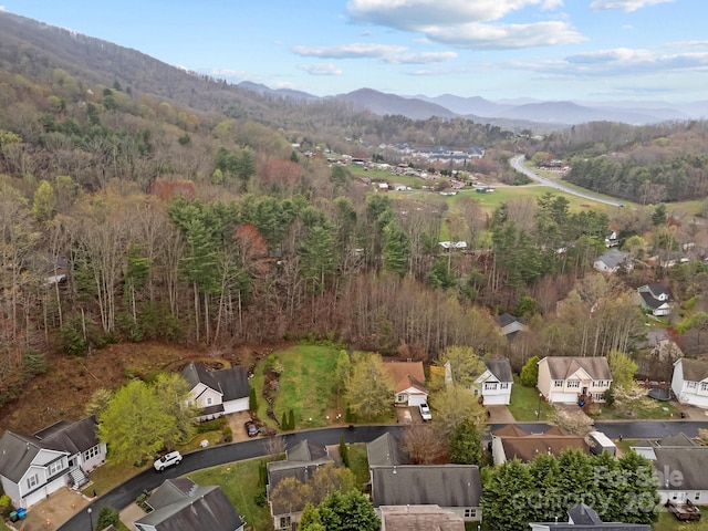 aerial view with a wooded view, a mountain view, and a residential view
