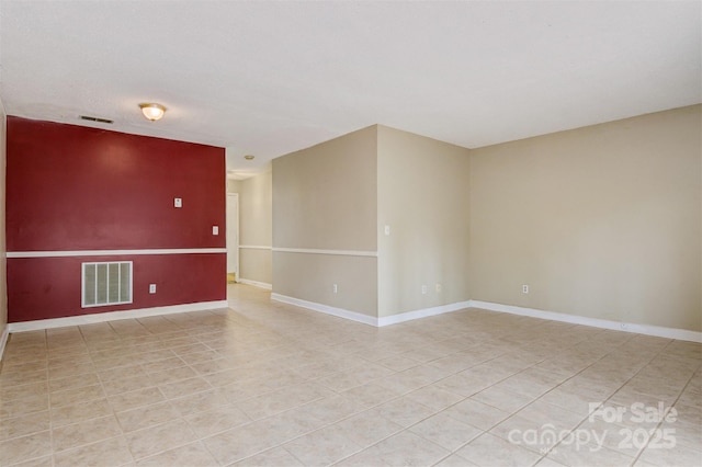 unfurnished room featuring light tile patterned floors, baseboards, and visible vents