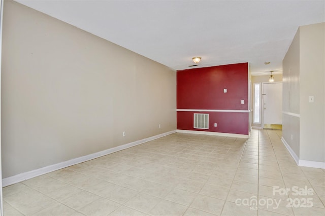 unfurnished room featuring baseboards, light tile patterned floors, and visible vents