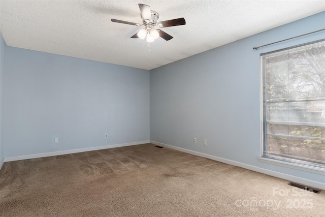 unfurnished room with a ceiling fan, plenty of natural light, visible vents, and carpet floors