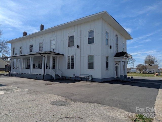 exterior space featuring board and batten siding, a porch, and crawl space