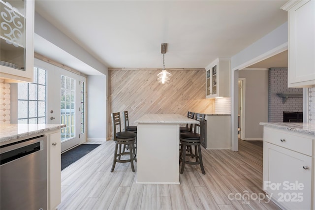 4487 Catawba Burris Rd, Denver, NC 28037 - dining room featuring light wood-style flooring, a brick fireplace, wood walls, and baseboards