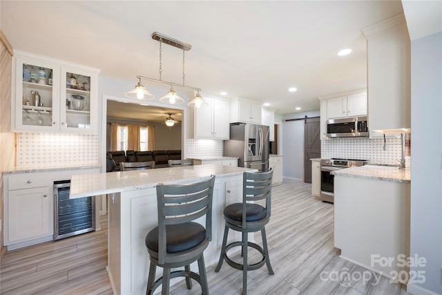 4487 Catawba Burris Rd, Denver, NC 28037 - kitchen featuring white cabinetry, stainless steel appliances, a sink, a barn door, and beverage cooler