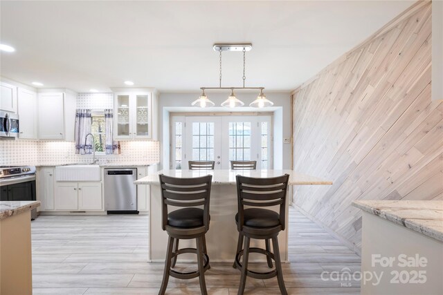 4487 Catawba Burris Rd, Denver, NC 28037 - kitchen featuring decorative backsplash, white cabinets, stainless steel appliances, a sink, and light stone counters