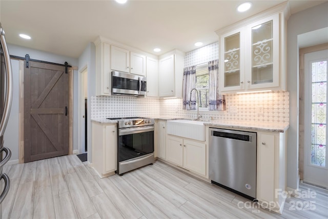 4487 Catawba Burris Rd, Denver, NC 28037 - kitchen featuring stainless steel appliances, backsplash, a sink, a barn door, and light stone counters