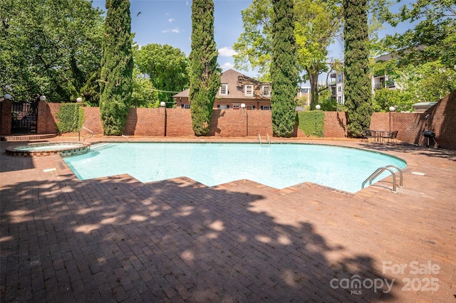 view of pool featuring a pool with connected hot tub, a patio, and a fenced backyard