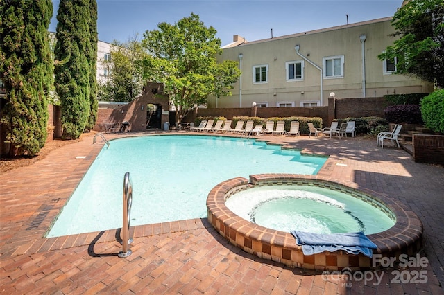 view of swimming pool featuring a patio, a pool with connected hot tub, and fence