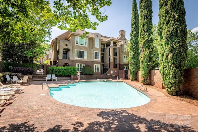 view of swimming pool featuring fence, a fenced in pool, and a patio area