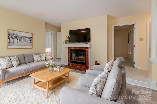 living room with a fireplace and baseboards