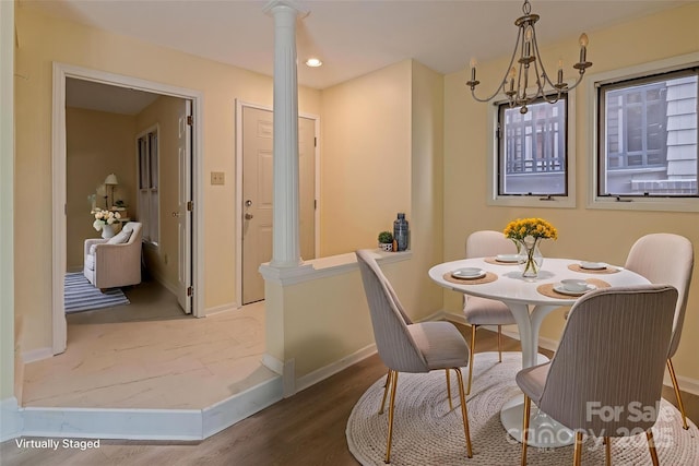 dining area with a notable chandelier, baseboards, ornate columns, and wood finished floors