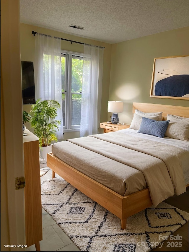 bedroom with visible vents and a textured ceiling