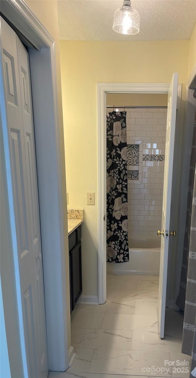 bathroom with a textured ceiling, marble finish floor, and vanity