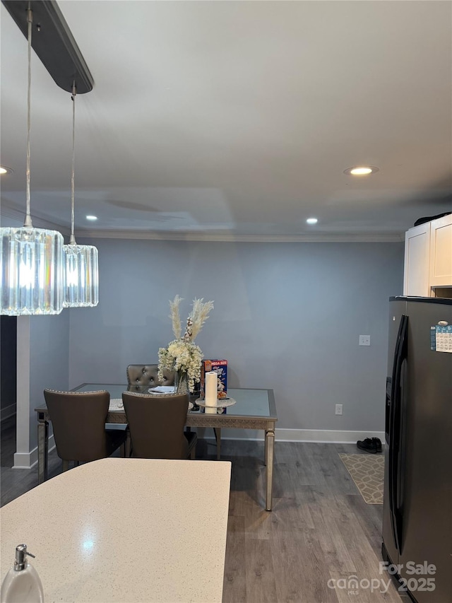 dining area with recessed lighting, dark wood-style flooring, crown molding, and baseboards