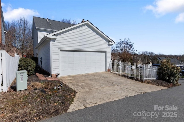 view of home's exterior featuring concrete driveway, fence, and an attached garage