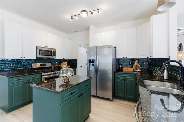 kitchen with green cabinets, white cabinetry, a sink, and appliances with stainless steel finishes