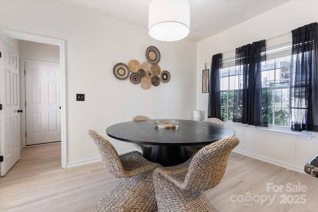 dining room featuring baseboards and light wood-type flooring