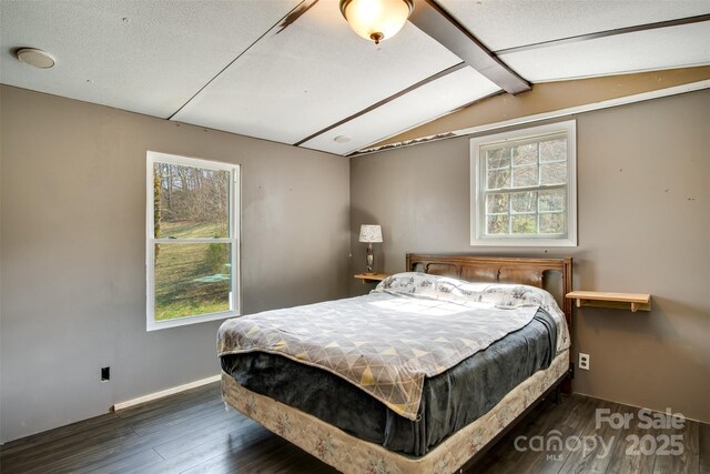bedroom featuring lofted ceiling with beams, baseboards, and wood-type flooring