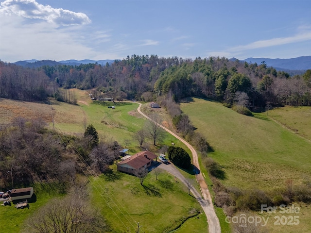 aerial view with a forest view, a mountain view, and a rural view
